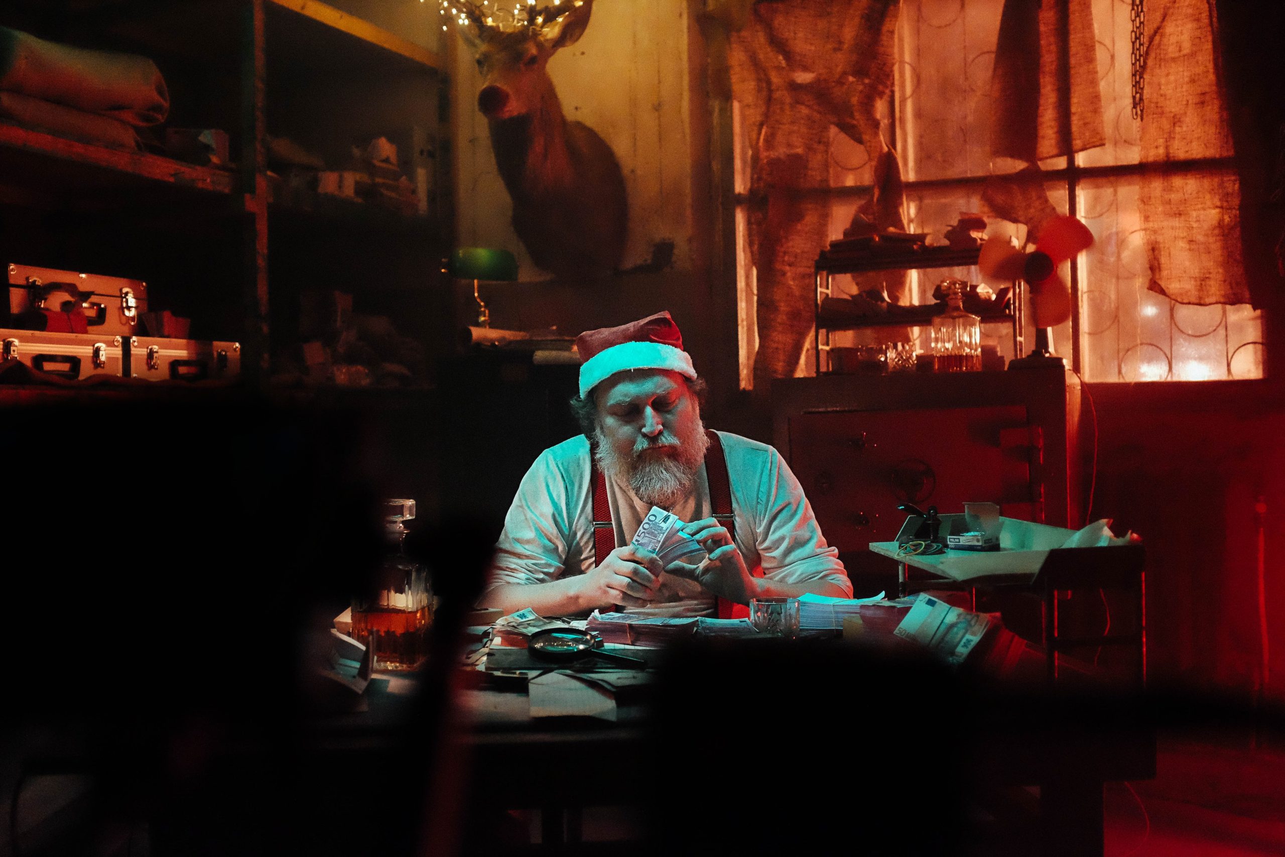 man-in-santa-hat-sitting-on-chair-counting-money-3480330